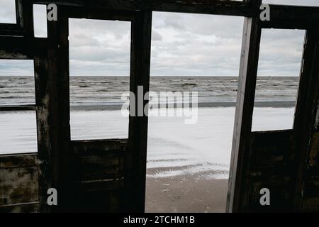 Une vue imprenable sur le paysage marin de Liepaja, Lettonie à travers un cadre de fenêtre rustique. Banque D'Images