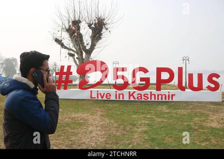 Bharti Airtel dévoile une technologie 5G de pointe 12 décembre 2023, Srinagar Cachemire, Inde : Un homme parle sur son téléphone portable après Airtel5Gplus est vu sur les rives du lac Dal pendant l'expérience 5G plus en direct à Srinagar. Airtel a annoncé le lancement de ses services 5G de pointe en octobre 2022 dans 8 villes en Inde. Aujourd'hui, les services d'Airtel sont en direct dans tous les États et territoires de l'Union de l'Inde avec plus de 50 millions de clients au 1 octobre 2023. Srinagar Kashmir India Copyright : xFirdousxNazirxxEyepixxGroupx Banque D'Images