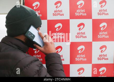 Bharti Airtel dévoile une technologie 5G de pointe 12 décembre 2023, Srinagar Cachemire, Inde : Un homme parle sur son téléphone portable le logo passé d'Airtel 5G plus est vu pendant l'expérience 5G plus en direct à Srinagar. Airtel a annoncé le lancement de ses services 5G de pointe en octobre 2022 dans 8 villes en Inde. Aujourd'hui, les services d'Airtel sont en direct dans tous les États et territoires de l'Union de l'Inde avec plus de 50 millions de clients au 1 octobre 2023. Srinagar Kashmir India Copyright : xFirdousxNazirxxEyepixxGroupx Banque D'Images