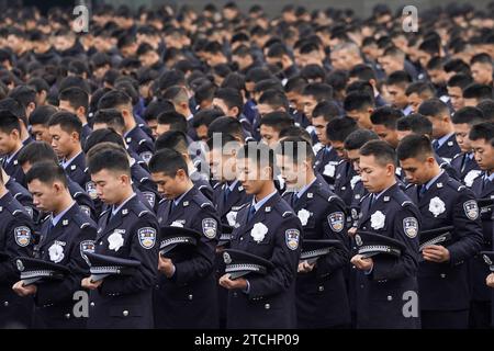 Nanjing, province chinoise du Jiangsu. 13 décembre 2023. Les gens observent une minute de silence lors de la cérémonie commémorative nationale pour les victimes du massacre de Nanjing au Memorial Hall of the Victims in Nanjing massacre par des envahisseurs japonais à Nanjing, capitale de la province de Jiangsu en Chine orientale, le 13 décembre 2023. Les habitants de Nankin ont observé un moment de silence et des sirènes ont été entendues dans toute la ville alors que la Chine organisait mercredi une cérémonie commémorative pour pleurer les 300 000 victimes du massacre de Nankin. Crédit : Li Bo/Xinhua/Alamy Live News Banque D'Images