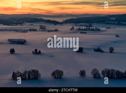 Photo drone du paysage bavarois avec vue sur la ville, brouillard dans la soirée peu après le coucher du soleil à Marktoberdorf, Allemagne, 3 décembre 2023. Banque D'Images