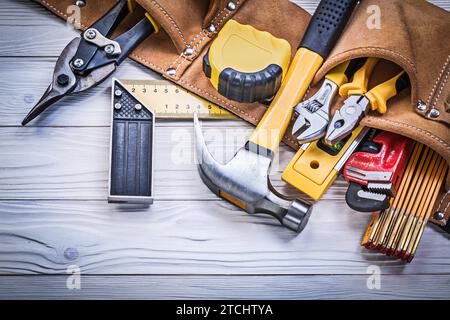 Ceinture à outils en cuir avec outils de construction sur plaque en bois concept d'entretien Banque D'Images