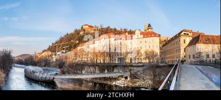 Graz, Styrie Autriche, 20.01.2019 : vue panoramique sur la rivière mur, Murinsel sur le pont, colline Schlossberg avec forteresse et tour de l'horloge Uhrturm. Voyages Banque D'Images