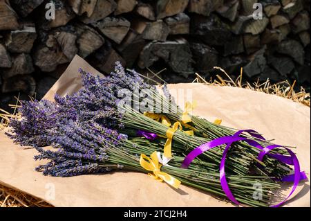 Des bouquets de lavande avec des rubans violets et jaunes reposent sur du papier kraft Banque D'Images