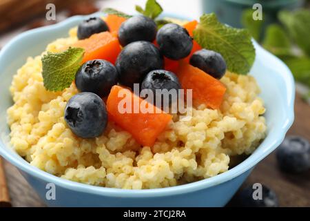 Savoureux porridge de millet avec des myrtilles, citrouille et menthe dans un bol sur la table, gros plan Banque D'Images