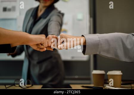 Collègues qui donnent un coup de poing pour célébrer la réussite professionnelle ou la réussite professionnelle. Banque D'Images