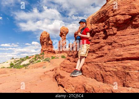 Boy debout près de Balanced Rock dans le parc national des Arches dans l'Utah. Photo de paysage en été Banque D'Images