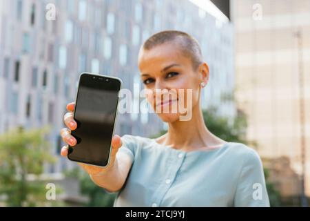 Connectivité urbaine : Femme déconcentrée à l'aide d'un smartphone dans le cadre de la ville Banque D'Images