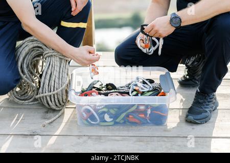 Gros plan des mains d'un homme faisant fonctionner un rocher dispositif de transmission de la bande d'escalade Banque D'Images
