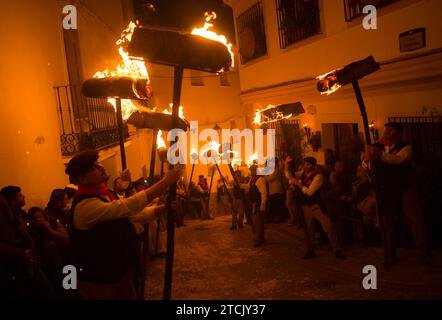 On voit des villageois tenant des torches dans une rue alors qu'ils participent à la célébration de la procession de la Vierge 'Divina Pastora' à la veille de la fête de Santa Lucia dans le petit village de Casarabonela, les villageois prennent part à l'ancienne célébration de 'Los Rondeles' tous les soirs du 12 décembre pendant la période de Noël, portant des paniers en osier brûlants (également connus sous le nom de 'rondeles') trempés dans l'huile. Dans les rues, la Vierge de Los Rondeles est honorée par les fidèles dans un rituel de lumière et de feu en remerciement pour la moisson. Banque D'Images