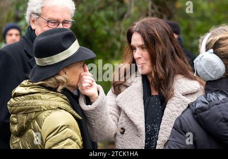 Chemnitz, Allemagne. 13 décembre 2023. Katarina Witt (droite), double championne olympique de patinage artistique, essuie une larme sur le visage de Gabriele 'Gaby' Seyfert, fille de Jutta Müller, lors des funérailles de l'entraîneur de patinage artistique Jutta Müller, décédé début novembre. L'ancien entraîneur vedette a été enterré au cimetière municipal entouré de parents, d'amis, d'anciens athlètes et de collègues. Müller est considérée comme l'entraîneure féminine de patinage artistique la plus performante. Elle aurait eu 95 ans le jour de ses funérailles. Crédit : Kristin Schmidt/dpa-Zentralbild/dpa/Alamy Live News Banque D'Images