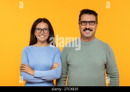 Heureux vieux couple européen en lunettes, souriant et debout avec confiance les bras croisés Banque D'Images