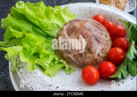 Viande gelée maison avec moutarde et raifort sur la table. Aspic. Gelée maison avec moutarde, tomates et ail sur la table. Kholodets, trad Banque D'Images