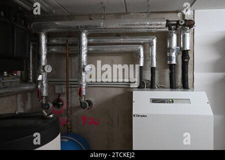 Munich, Allemagne. 13 décembre 2023. Une pompe à chaleur eau-eau avec puits est installée au sous-sol d'une maison individuelle. À partir de janvier, seuls les systèmes de chauffage basés sur 65 % d'énergie renouvelable pourront être installés dans les nouveaux bâtiments situés dans de nouvelles zones de développement. Dans de nombreux cas, il s'agit probablement d'une pompe à chaleur. Crédit : Felix Hörhager/dpa/Alamy Live News Banque D'Images