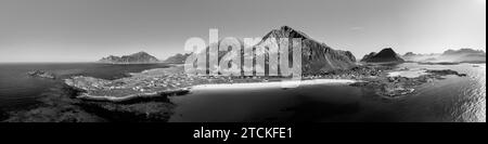 Panorama monochrome de drone sur la baie de Jusnesvika et la plage de Rambergstranda sur l'île de Flakstadoya, Lofoten, avec des contrastes saisissants entre les eaux sombres, bri Banque D'Images