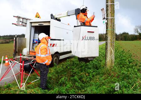 Deux ingénieurs ajustant le câble à fibre optique, Bolazec, Bretagne Bretagne, France Banque D'Images