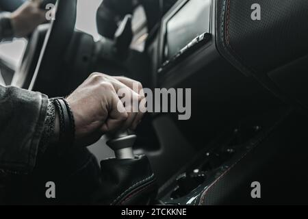 Conducteur caucasien derrière le volant de voiture de sport conduisant la transmission manuelle Banque D'Images