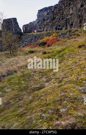Islande, cercle d'Or, Parc National de Thingvellir aux couleurs de l'automne. Le rift médio-atlantique entre les plaques tectoniques nord-américaine et eurasienne. Almannagja gorge marquant le bord de la plaque tectonique nord-américaine, avec des touristes touristiques. Banque D'Images