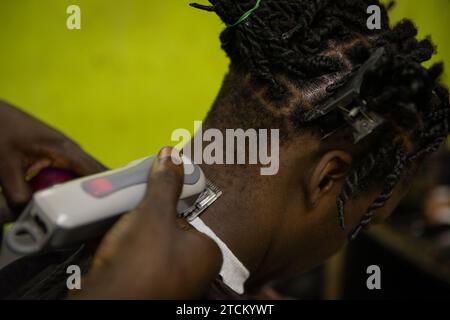 Gros plan d'un rasoir utilisé par un barbier pour couper les cheveux de son client. Banque D'Images