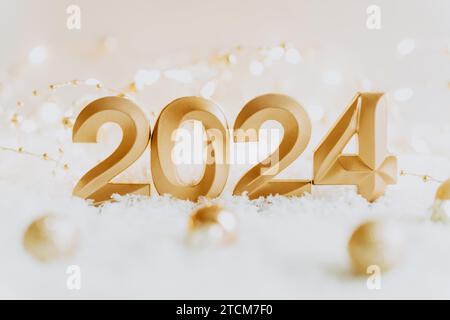 Carte de voeux - bonne année avec les numéros 2024 dans la neige artificielle sur fond blanc. Concept de vacances minimal. Vue avant. Espace de copie Banque D'Images