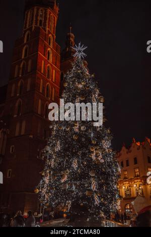 Cracovie, Pologne, place du marché principal et salle aux tissus en hiver, pendant les foires de Noël décorées avec sapin de Noël. Banque D'Images