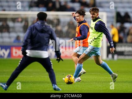 Callum O'Hare (au centre) et Liam Kitching (à droite) de Coventry City se réchauffent avant le match du championnat Sky Bet au Coventry Building Society Arena, Coventry. Date de la photo : mercredi 13 décembre 2023. Banque D'Images