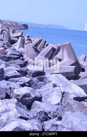 Penrhyn Bay, pays de Galles, Royaume-Uni 7 juin 2023 structures en béton déployées le long de la région de Colwyn Bay, conçues pour verrouiller et fournir une barrière défensive contre les vagues et protéger le littoral. Les blocs sont conçus avec un motif en forme de T de sorte que plutôt que d'être balayés individuellement, ils s'interconnectent pour fournir une barricade de roche et un mur de brise ©GED Noonan/Alamy Banque D'Images