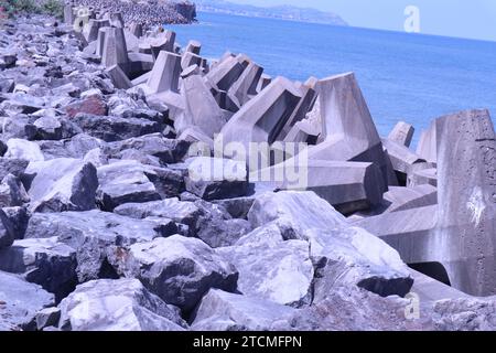 Penrhyn Bay, pays de Galles, Royaume-Uni 7 juin 2023 structures en béton déployées le long de la région de Colwyn Bay, conçues pour verrouiller et fournir une barrière défensive contre les vagues et protéger le littoral. Les blocs sont conçus avec un motif en forme de T de sorte que plutôt que d'être balayés individuellement, ils s'interconnectent pour fournir une barricade de roche et un mur de brise ©GED Noonan/Alamy Banque D'Images