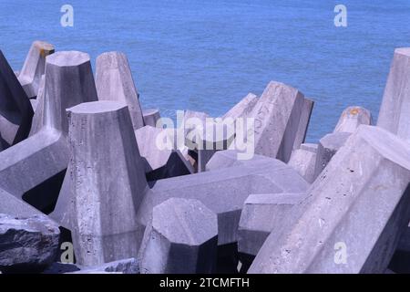 Penrhyn Bay, pays de Galles, Royaume-Uni 7 juin 2023 structures en béton déployées le long de la région de Colwyn Bay, conçues pour verrouiller et fournir une barrière défensive contre les vagues et protéger le littoral. Les blocs sont conçus avec un motif en forme de T de sorte que plutôt que d'être balayés individuellement, ils s'interconnectent pour fournir une barricade de roche et un mur de brise ©GED Noonan/Alamy Banque D'Images