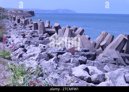 Penrhyn Bay, pays de Galles, Royaume-Uni 7 juin 2023 structures en béton déployées le long de la région de Colwyn Bay, conçues pour verrouiller et fournir une barrière défensive contre les vagues et protéger le littoral. Les blocs sont conçus avec un motif en forme de T de sorte que plutôt que d'être balayés individuellement, ils s'interconnectent pour fournir une barricade de roche et un mur de brise ©GED Noonan/Alamy Banque D'Images