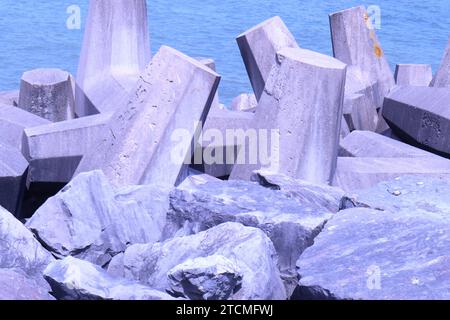 Penrhyn Bay, pays de Galles, Royaume-Uni 7 juin 2023 structures en béton déployées le long de la région de Colwyn Bay, conçues pour verrouiller et fournir une barrière défensive contre les vagues et protéger le littoral. Les blocs sont conçus avec un motif en forme de T de sorte que plutôt que d'être balayés individuellement, ils s'interconnectent pour fournir une barricade de roche et un mur de brise ©GED Noonan/Alamy Banque D'Images