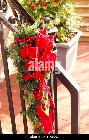 Noël Bough noué avec ruban rouge sur la rampe d'escalier extérieur Banque D'Images