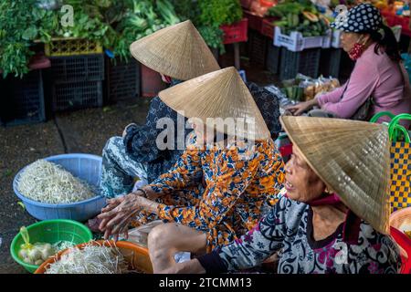 Femmes portant des chapeaux de paille traditionnels - non la - au marché de Hoi an, Vietnam Banque D'Images