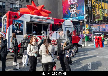 Les gens attendent sur la ligne pour un chocolat chaud gratuit à une activation de marque du film « Candy Cane Lane » d’Amazon Prime Videos avec Eddie Murphy, à Times Square à New York le samedi 2 décembre 2023. (© Richard B. Levine) Banque D'Images