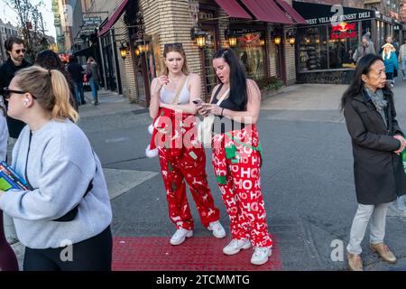 Des centaines de Santas, accompagnés de leurs assistants et de quelques elfes coquins, envahissent Manhattan à New York pour le bar crawl annuel, SantaCon le samedi 19 décembre 2023. SantaCon, principalement un bar crawl dans le Père Noël et d'autres costumes liés à Noël, attire les masqueradeurs qui vont de bar en bar. (© Richard B. Levine) Banque D'Images