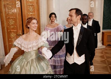 Portrait de couples de la Renaissance classique suivant en ligne appréciant le bal de danse dans le palais Banque D'Images