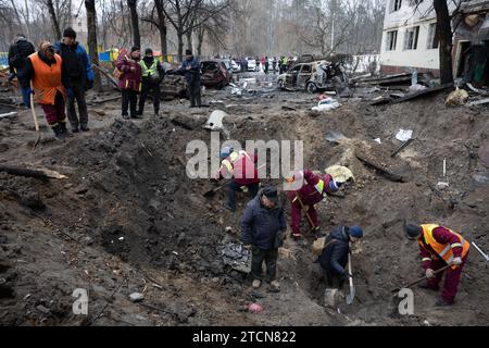 Kiev, Ukraine. 13 décembre 2023. Les travailleurs des services publics remplissent le cratère créé par l'explosion d'un missile russe à Kiev. Au moins 53 personnes ont été blessées aux premières heures du 13 décembre à la suite de la chute de débris de missiles dans plusieurs districts de la capitale ukrainienne Kiev, après que les systèmes de défense aérienne ont intercepté des cibles balistiques russes entrantes. (Photo Oleksii Chumachenko/SOPA Images/Sipa USA) crédit : SIPA USA/Alamy Live News Banque D'Images