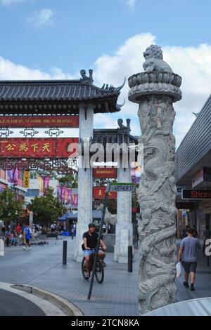 Une colonne de dragon en pierre sculptée surmontée d'un lion devant les portes cérémonielles chinoises Cabramatta, Pai Lau, sur le centre commercial Cabaramatta, Western Sydney Banque D'Images