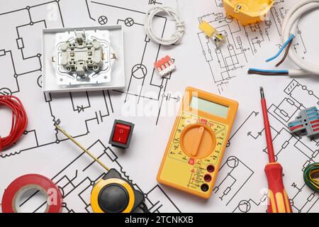 Équipement d'électricien différent et tournevis sur les schémas de câblage, pose à plat Banque D'Images