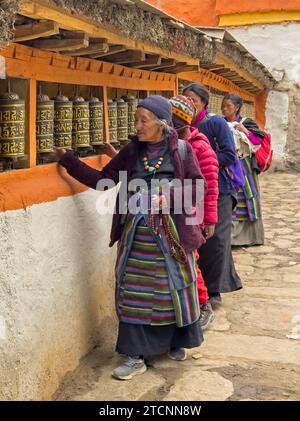 Les pèlerins tournent des roues de prière au monastère de Lo Gekar dans le village de Ghar, le plus ancien gompa bouddhiste au Népal, construit par Guru Rimpoche au 8e siècle - Mus Banque D'Images