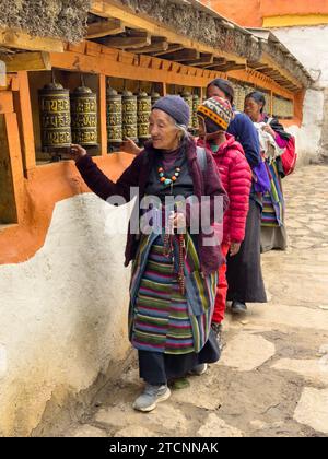 Les pèlerins tournent des roues de prière au monastère de Lo Gekar dans le village de Ghar, le plus ancien gompa bouddhiste au Népal, construit par Guru Rimpoche au 8e siècle - Mus Banque D'Images