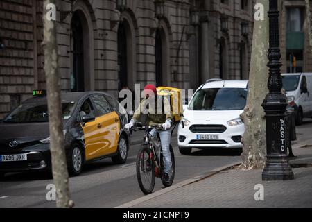 Barcelone, 03/18/2020. Confinement pendant l’état d’alarme dû au risque de contagion du coronavirus Covid 19. Dans l'image, un taxi et un livreur Glovo. PHOTOS INES BAUCELLS. ARCHDC. Crédit : Album / Archivo ABC / Inés Baucells Banque D'Images