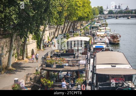 Piétons marchant le long des quais de Paris de France. Banque D'Images