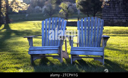 Deux chaises Adirondack vides dans une cour avec arrière-plan flou et lumière du soleil de rêve, Tewksbury, New Jersey, États-Unis Banque D'Images