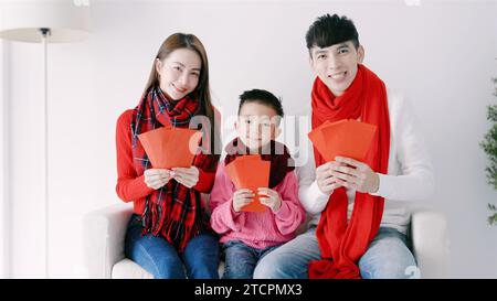 bonne année chinoise. famille asiatique montrant une enveloppe rouge pour célébrer le nouvel an chinois Banque D'Images