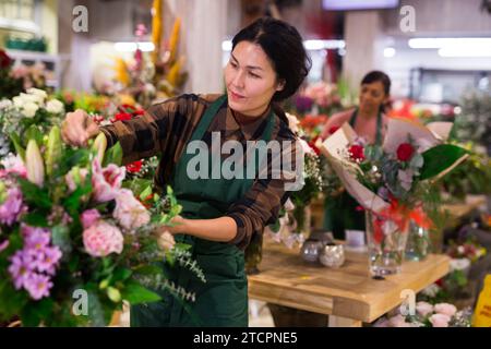 Le vendeur de fleurs asiatique prépare un bouquet de luxe à la boutique de fleurs Banque D'Images