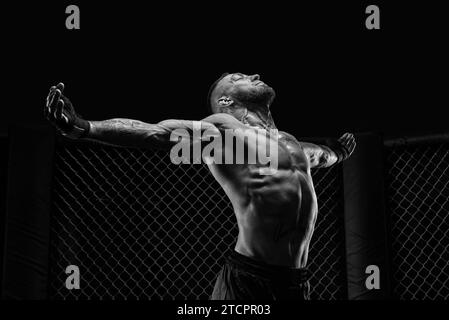 L'image dramatique en noir et blanc du combattant MMA. Photographie dans un véritable octogone. Combattant brutal. Supports mixtes Banque D'Images