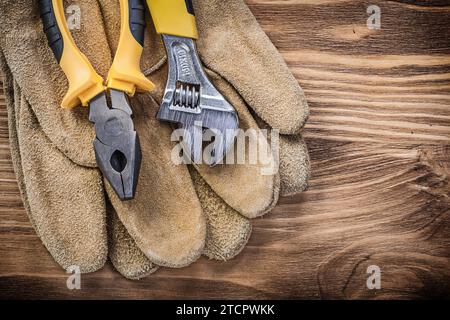 Gants de sécurité en cuir pince à clé réglable sur concept de construction de planche en bois Banque D'Images