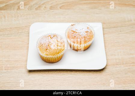 Muffins aux pommes maison avec du sucre blanc en poudre sur table en bois Banque D'Images