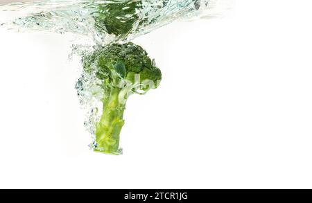 Gros plan de brocoli éclabousse dans l'eau isolée sur blanc. Concept d'alimentation saine Banque D'Images